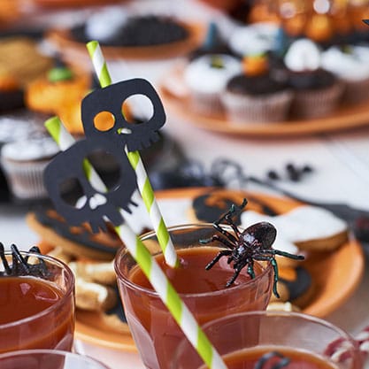 cocktail di Halloween decorato con ragni e cannucce sormontate da teschi