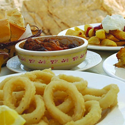 Aperitivo spagnolo accompagnato da tapas, polpo e anelli di calamari fritti